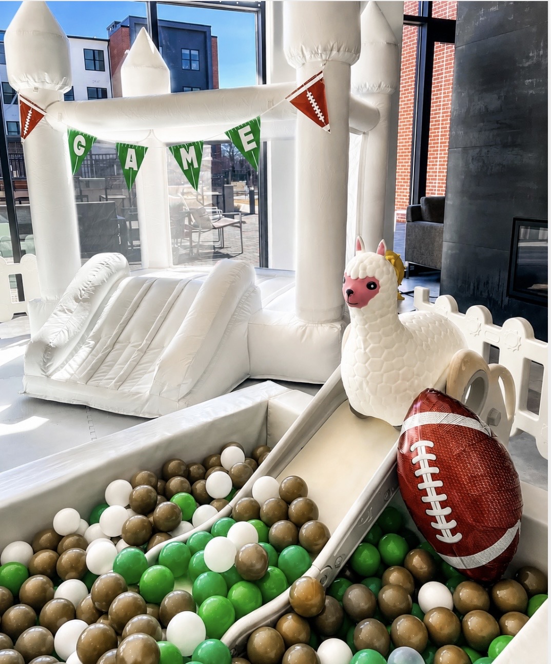 White bounce house with game-day ball pit setup